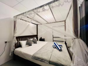 a bedroom with a bed with a canopy at Villa Eco Stay in Tangalle