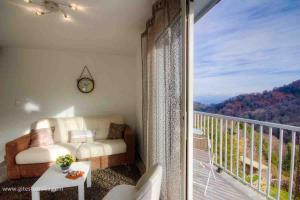 un salon avec un canapé et un balcon dans l'établissement Maison entre mer et montagne, à Santa-Reparata-di-Moriani