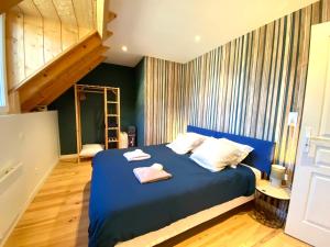 ein Schlafzimmer mit einem blauen Bett mit zwei Handtüchern darauf in der Unterkunft CHALET LAC BLEU Luchon proche Thermes 3ch terrasse bbq pkg 7p in Saint-Mamet