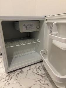 an empty refrigerator with its door open in a kitchen at BUNKA HOUSE OSAKA room d in Osaka