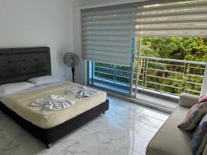 een slaapkamer met een bed en een groot raam bij centrico Apartamento con piscina Anapoima in Anapoima +14 foto's