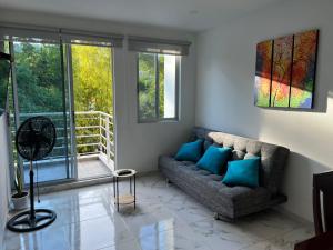 een woonkamer met een bank en een raam bij centrico Apartamento con piscina Anapoima in Anapoima