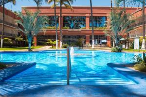 a swimming pool with a fountain in front of a building at Nk Hotel Nekié Tepic in Tepic