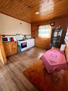 a kitchen with a table in the middle of a room at Cabaña Ñiucho Dalcahue in Dalcahue