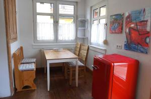 Il comprend une petite cuisine avec une table et un réfrigérateur rouge. dans l'établissement Gemütliche Künstlerwohnung mit großer Dachterrasse, à Weinheim