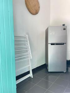 a white refrigerator in a room with a shelf at Amurasan beach studio in Tangalle