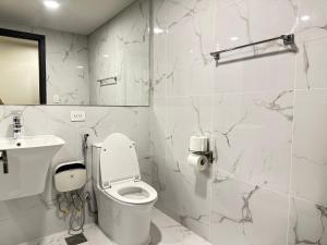 a white bathroom with a toilet and a sink at One Bedroom Unit - Ivory Residences Near DMSF Medical School & Abreeza Mall in Davao City +9 photos
