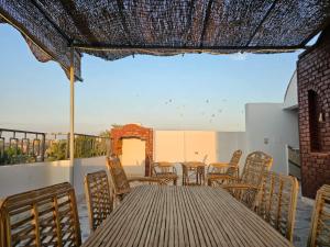 une table et des chaises sur le balcon d'une maison dans l'établissement nile shores hotel, à Al Aqālitah