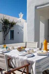 a table with a white tablecloth and chairs on a patio at Sunny Villa Sifnos in Apollonia