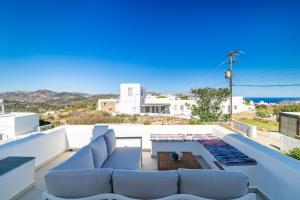 a living room with white furniture and the view of the ocean at Sunny Villa Sifnos in Apollonia