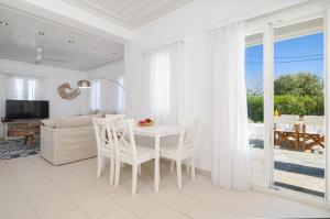 a white living room with a table and chairs at Sunny Villa Sifnos in Apollonia