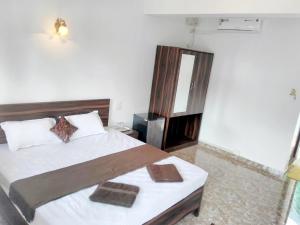 a bedroom with a bed with two towels on it at MŏřĜîm ɓɛač̣ĥ řőòm in Morjim