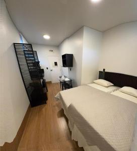 a bedroom with a bed and a television in it at 2Kitnet aconchegante no coração da cidade in Lavras