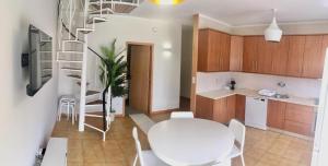 a kitchen with a white table and a spiral staircase at Azurara Martins House in Azurara