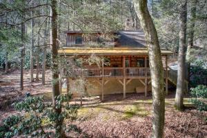 een blokhut in het bos met bomen bij Soothing Waters in Vilas