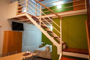 a loft bed in a room with a desk at Tribales del Este in Gualeguaychú +8 photos