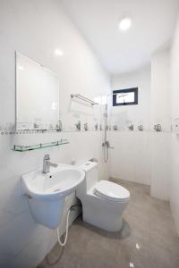 a white bathroom with a toilet and a sink at Bae Villa Đà Lạt in Da Lat