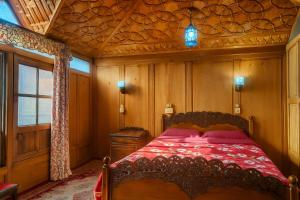 a bedroom with a bed with a wooden ceiling at Lalarukh Group of Houseboats in Srinagar