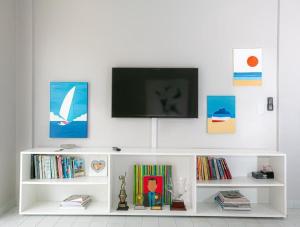 a white shelf with a television on top of it at Apartamento familiar com acesso privativo à Praia Mansa in Matinhos