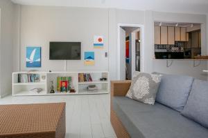 a living room with a couch and a tv at Apartamento familiar com acesso privativo à Praia Mansa in Matinhos