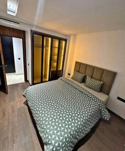 une chambre avec un grand lit dans une pièce dans l'établissement Résidence Al madmounae agadir, à Dcheïra