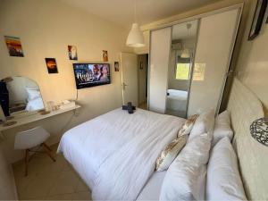 une chambre avec un grand lit blanc et un miroir dans l'établissement Résidence Al madmounae agadir, à Dcheïra