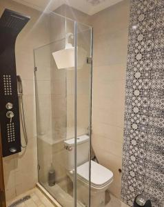 une salle de bain avec toilettes et douche en verre dans l'établissement Résidence Al madmounae agadir, à Dcheïra