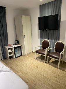 a hotel room with two chairs and a flat screen tv at pyramids heaven inn in Giza