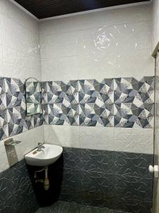 a bathroom with a sink and a tiled wall at Mangattu Salkara highway view retreat in Anniyartholu +26 photos