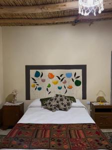 a bedroom with a bed with a picture on the wall at By Lela in Tinogasta +10 photos