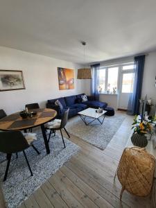 a living room with a blue couch and a table at Nice home with free parking close to downtown and nature! in Copenhagen