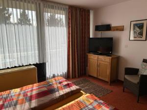 a hotel room with a bed and a flat screen tv at Ferienwohnung mit Schwimmbad und Gartenblick in Sankt Englmar