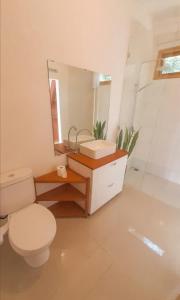 a bathroom with a toilet and a mirror at Mimpi Manis Villas in Tetebatu