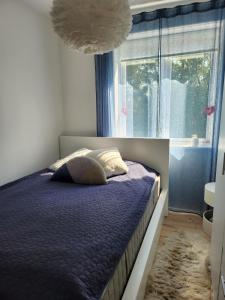 a bedroom with a bed with a purple comforter and a window at Nice home with free parking close to downtown and nature! in Copenhagen +28 photos