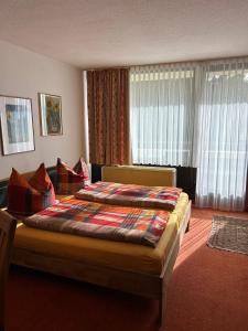 een slaapkamer met een bed en een groot raam bij Ferienwohnung mit Schwimmbad und Gartenblick in Sankt Englmar