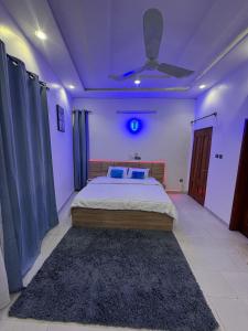 a bedroom with a bed and a ceiling fan at Borabora in Cotonou +4 photos