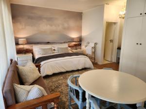 a hotel room with a bed and a table at At Let Se Plek in Jeffreys Bay