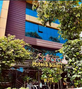 a sign for a hotel and bakery in front of a building at Mangattu Salkara highway view retreat in Anniyartholu