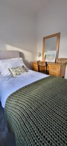 a bedroom with a bed and a dresser and a mirror at The Willows, Yarm in Stockton-on-Tees +3 photos
