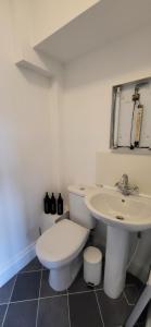 a white bathroom with a toilet and a sink at The Willows in Stockton-on-Tees