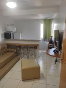 a kitchen and a living room with a couch and a table at Flat de 1 Qto Golden Dolphin Roberto Imóveis in Caldas Novas