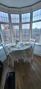 a dining room with a table and chairs and windows at The Willows in Stockton-on-Tees