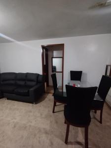 een woonkamer met een zwarte bank en een tafel bij Apartment in Bogotá in Bogota