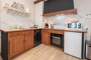 a kitchen with a sink and a dishwasher at Le Mas d'Angeline-Vue mer panoramique, jardin partagé, parking, voiture indispensable, route étroite et pentue, à 10 min de Monaco in Beausoleil