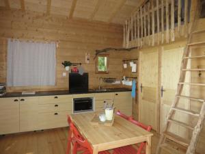 a kitchen with a ladder and a table in a room at La Cabane aux Sapins in Ratières