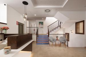 a lobby with a staircase and two chairs and a table at Hotel Vinoteca Alquezar - Adults Only - in Alquézar
