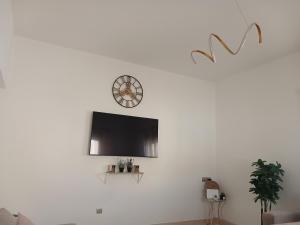 a living room with a tv on a white wall at Maison almassira in Agadir