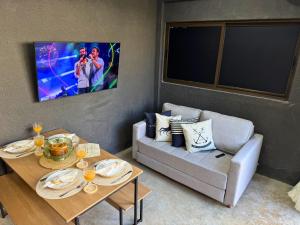 ein Wohnzimmer mit Sofa und Tisch in der Unterkunft MHV Milagres - Studio Guadalupe 05, quarto e sala privativo a poucos metros da Praia do Marceneiro in Passo de Camarajibe
