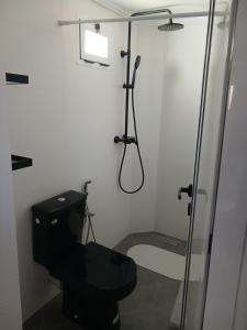 a bathroom with a black toilet and a shower at Maison almassira in Agadir +72 photos