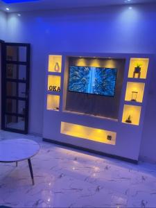 a living room with a tv on a wall at Oka in Déni Diarke